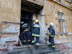 tűzoltók állnak és várják, hogy bemehessenek az épüeltbe