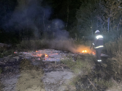 Tűzoltó oltja aszabadtéri tüzet 