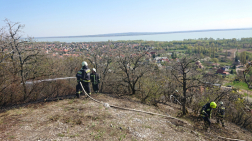 Kéziszerszámokkal és vízsugarakkal oltják a tüzet a tűzoltók